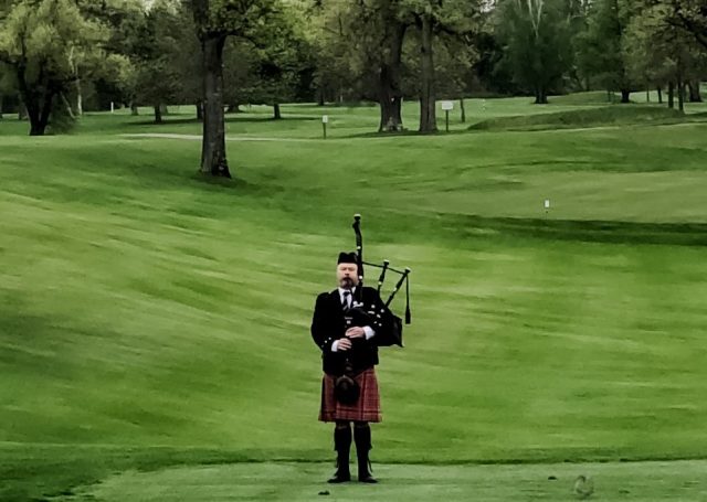 bagpiper plays from golf course